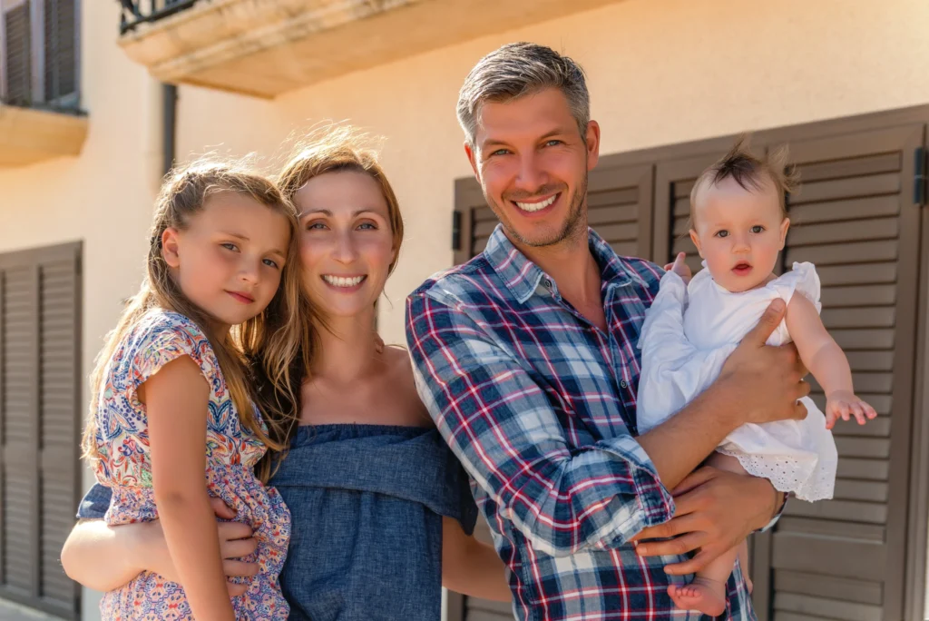 A happy Columbia, SC family in front of their home protected by a Cola City Roofing roof
